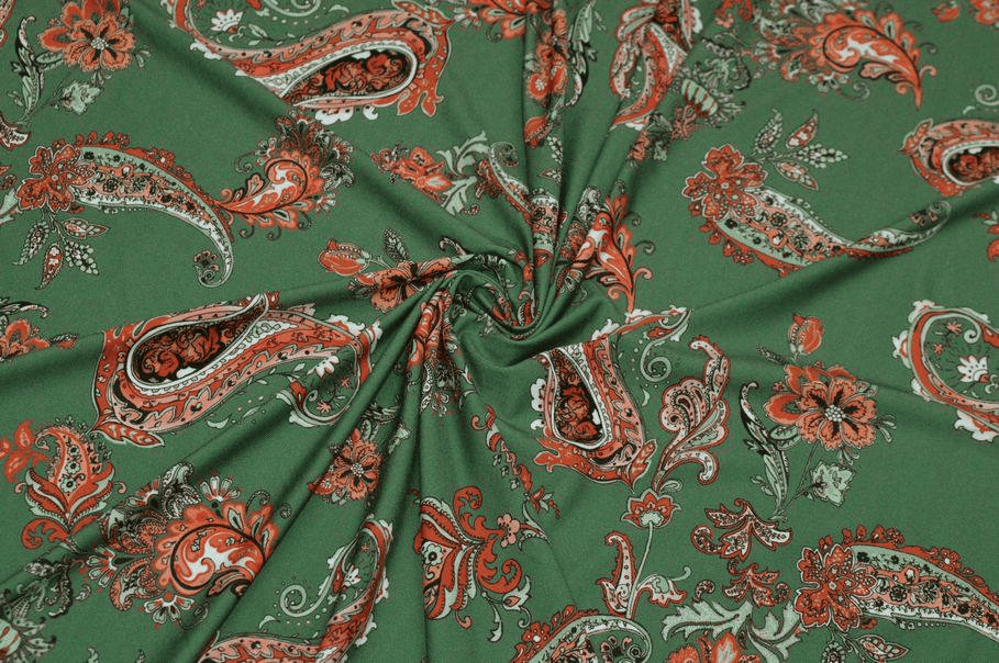 Dettaglio di lycra bielastica verde con fantasia floreale e geometrica per costumi.