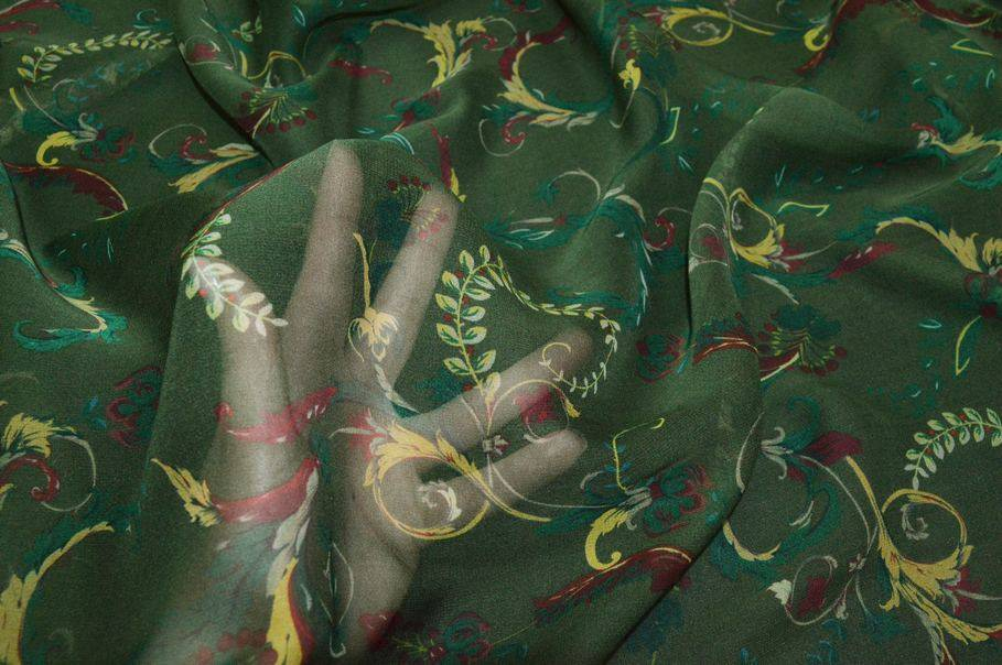Tessuto georgette pura seta con fantasia a tema floreale su sfondo verdone