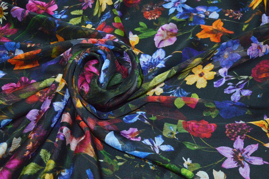 Tessuto chiffon pura seta con stampa floreale vivace su fondo nero per gonne eleganti