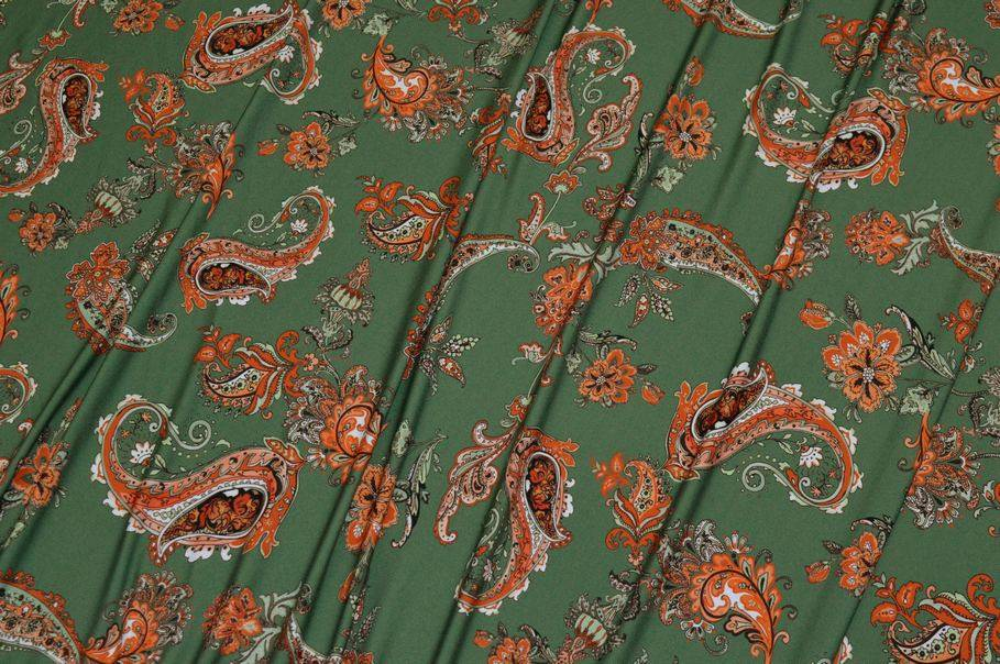 Dettaglio di tessuto lycra bielastica stampata con fantasia geometrica cashmere arancio e verde