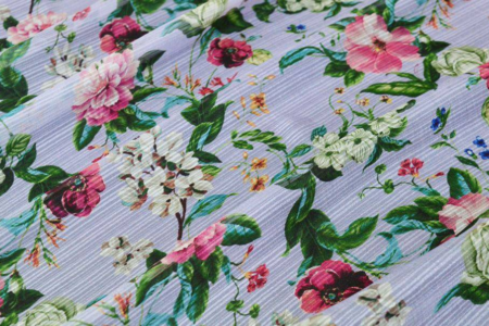 Tessuto chiffon in pura seta con fantasia floreale lilla, ideale per gonna a ruota